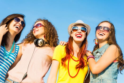 group of young people wearing sunglasses and hats hugging and standing in a row, spending time with friends