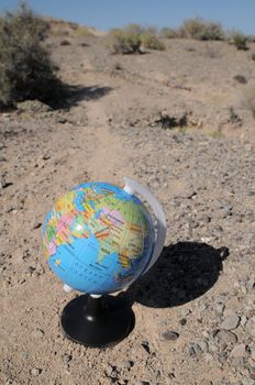 Globe on a road in a mountain desert