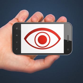 Security concept: hand holding smartphone with Eye on display. Generic mobile smart phone in hand on Dark Blue background.