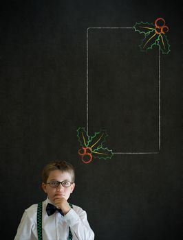Thinking boy dressed up as business man with Christmas holly to do checklist on blackboard background