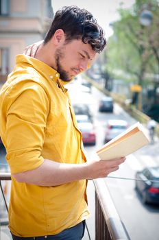 young man reading book on the balcony