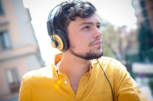 hipster young man listening to music on the balcony 