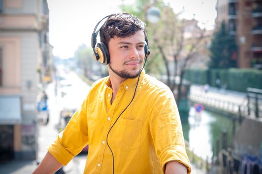 hipster young man listening to music on the balcony 