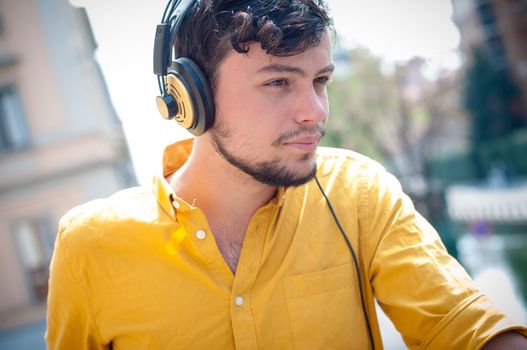hipster young man listening to music on the balcony 