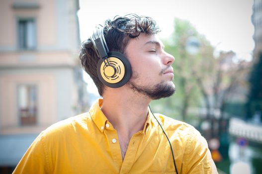 hipster young man listening to music on the balcony 