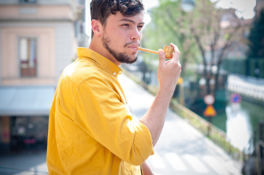 young man smoking pipe on the balcony