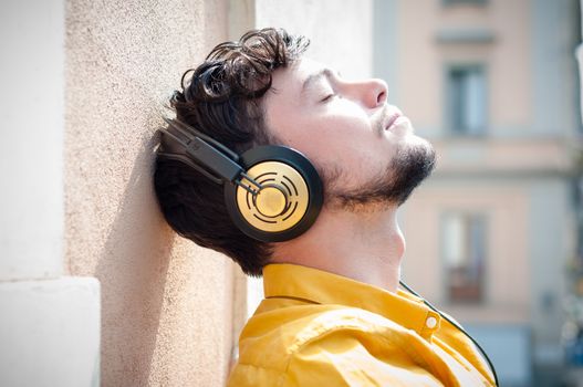 hipster young man listening to music on the balcony 