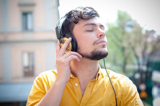 hipster young man listening to music on the balcony 