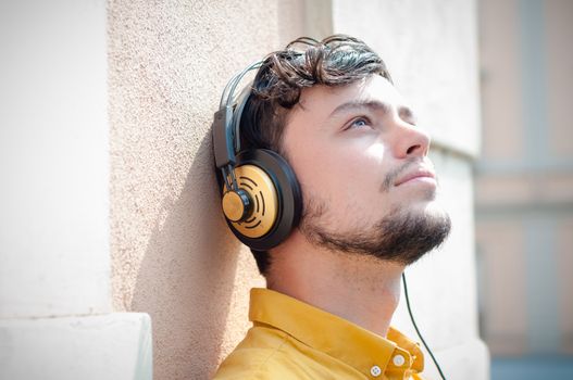 hipster young man listening to music on the balcony 