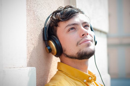 hipster young man listening to music on the balcony 