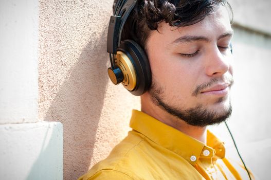 hipster young man listening to music on the balcony 