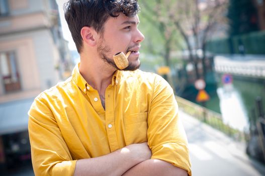 young man smoking pipe on the balcony