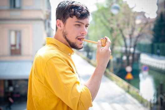 young man smoking pipe on the balcony