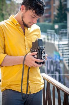 hipster young man with old camera on the balcony