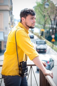 hipster young man with old camera on the balcony