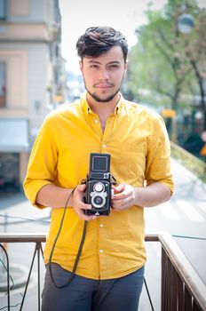 hipster young man with old camera on the balcony