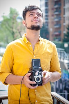 hipster young man with old camera on the balcony
