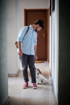 hipster young man posing with jack russell dog in a hallway
