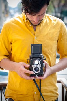 hipster young man with old camera on the balcony