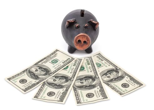 Money and black piggy bank on white background.