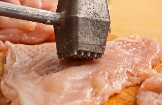 Prepearing chicken meat with hammer