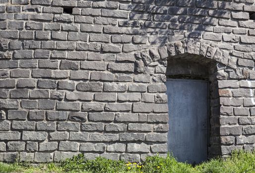 surface texture of old stone wall with blue door