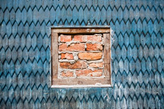 wooden wall of the old house and window with bricks