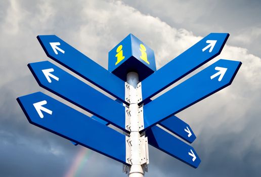 Blank directional road signs over rainbow