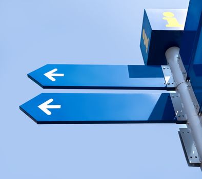 Blank directional road signs over blue sky