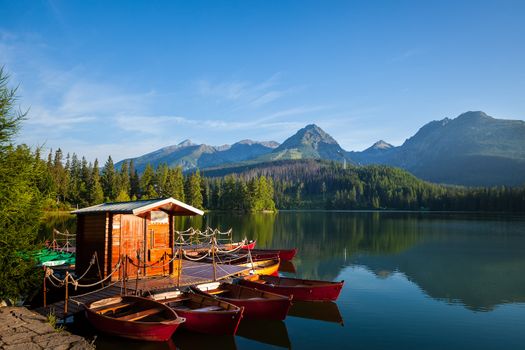 Red boats on mountain lake in National Park High Tatra. Strbske pleso, Slovakia, Europe