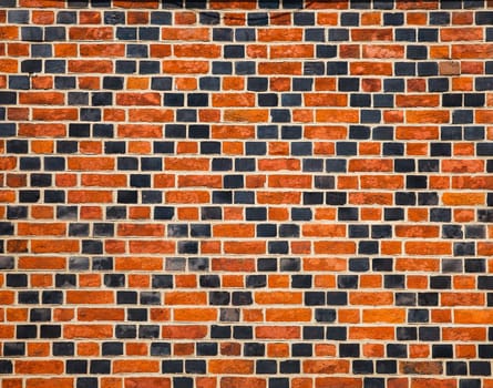 Decorative ornament made ������by red and black bricks on wall of an old house