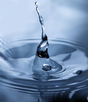 Drop of water in blue. Splash of water close up