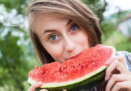 Young woman with watermelon outdoors