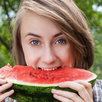 Young woman with watermelon outdoors