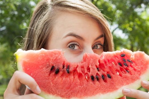 Young woman with watermelon outdoors