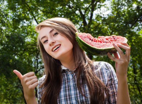 Young woman with watermelon outdoors