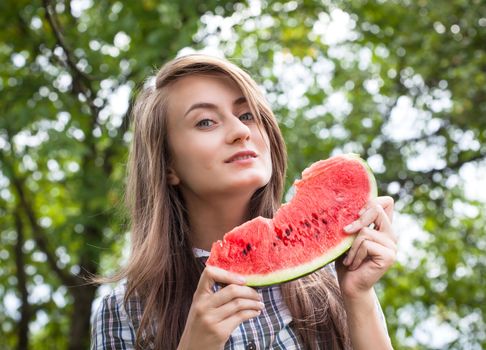 Young woman with watermelon outdoors