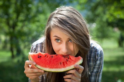 Young woman with watermelon outdoors