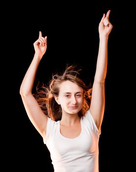 Portrait of a beautiful young woman dancing on a dark background