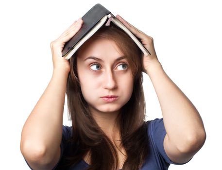 Education. Tired girl holds a notebook on her head on a white background