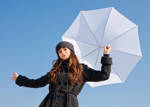 Girl with white  umbrella on blue sky background