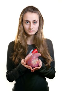Young woman with a heart in her hand on white background. Focus mainly on the face.