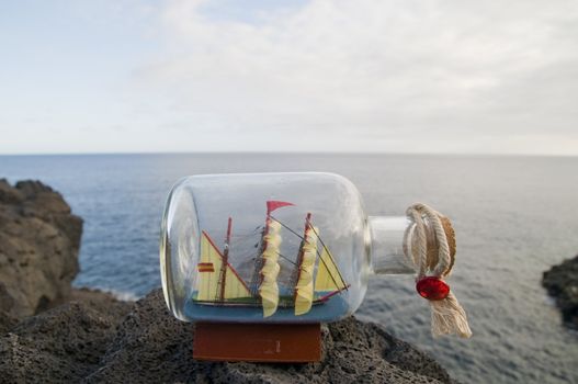 Vessel in a glass bottle on a rock near the atlantic ocean in Tenerife