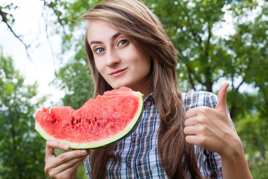 Young woman with watermelon outdoors