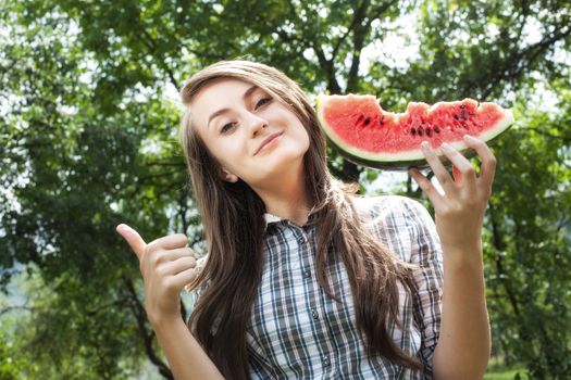 Young woman with watermelon outdoors