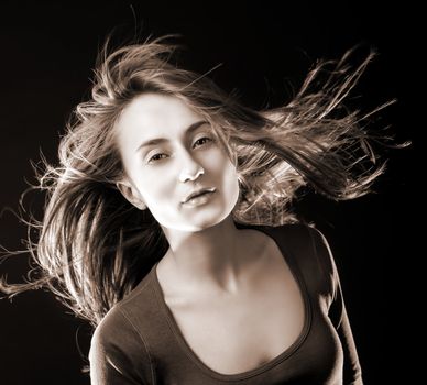 Portrait of a beautiful young woman with hair flying