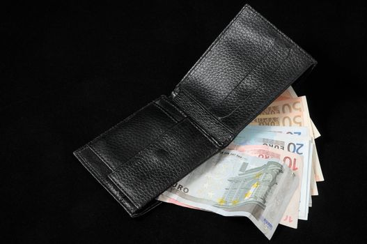 Wallet with euro currency on a dark background