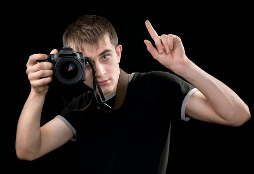 Young photographer at work isolated on black background