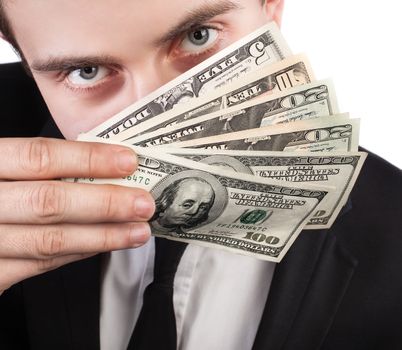 Close-up portrait of a businessman with a fan of dollars covering his face