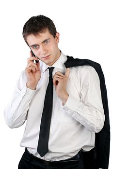 Handsome businessman standing with jacket over shoulder in white shirt and talking on mobile